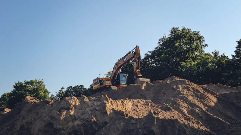Excavator moving earth on a graded site