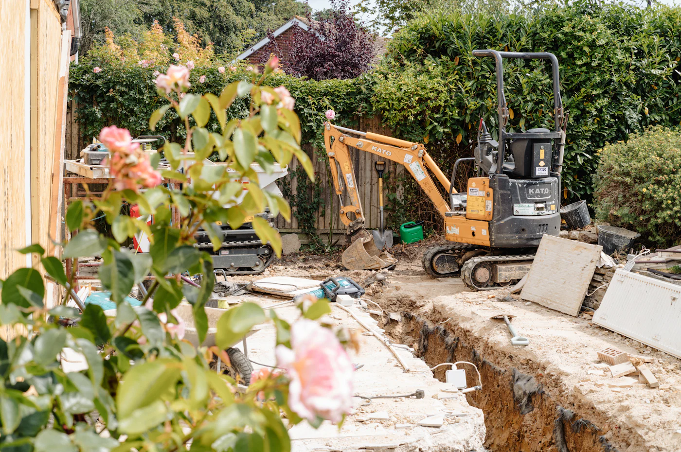 Mini excavator digging a utility trench in a residential backyard